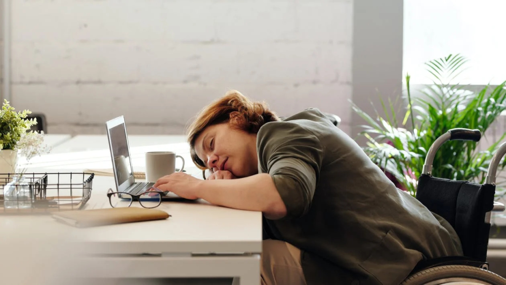 Sleeping woman with her head on her laptop doing work. 